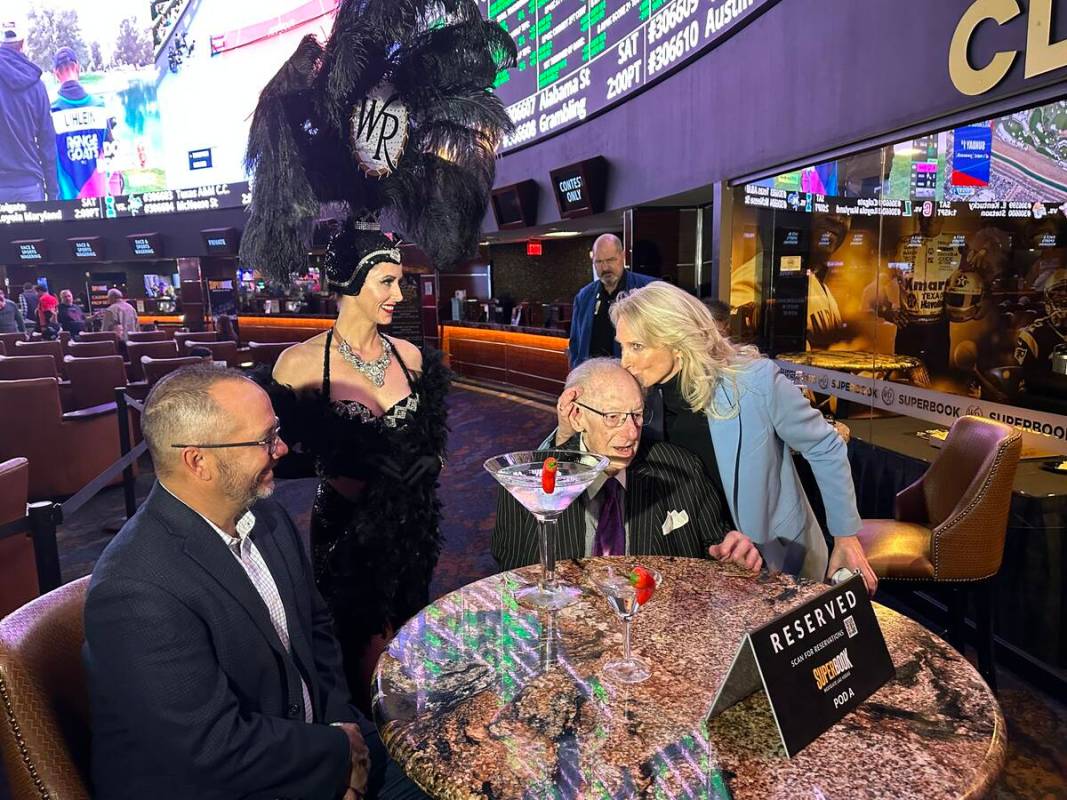 Westgate President and GM Cami Christensen plants one on former mayor and current gambler Oscar ...