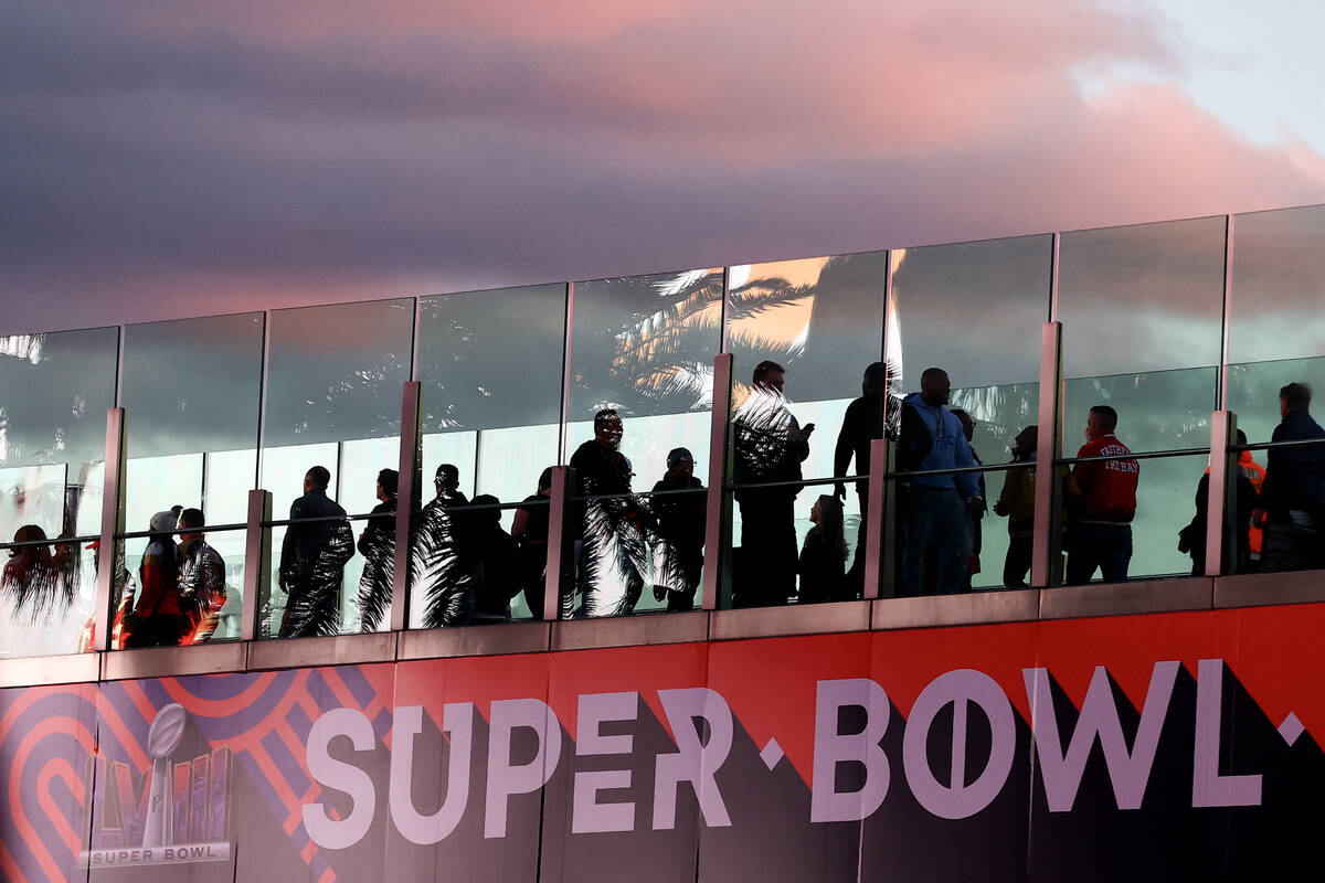 People cross a pedestrian bridge Saturday, Feb. 10, 2024, on the Las Vegas Strip. The NFL Super ...