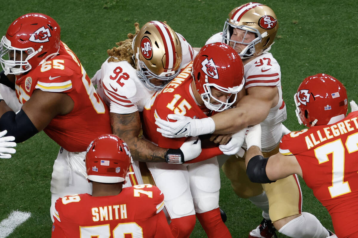 San Francisco 49ers defensive end Chase Young (92) and defensive end Nick Bosa (97) tackle Kans ...