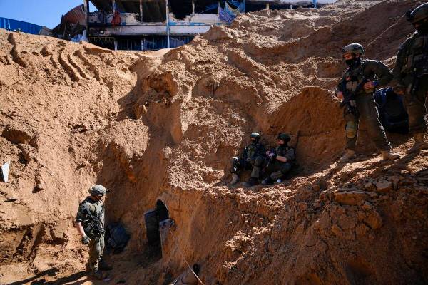 Israeli soldiers guard a crater-like hole giving way to a small tunnel entrance in the UNRWA co ...