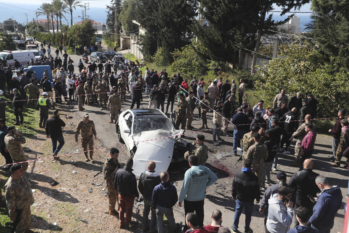 Lebanese army soldiers gather around a damaged car near the coastal town of Jadra, south Lebano ...