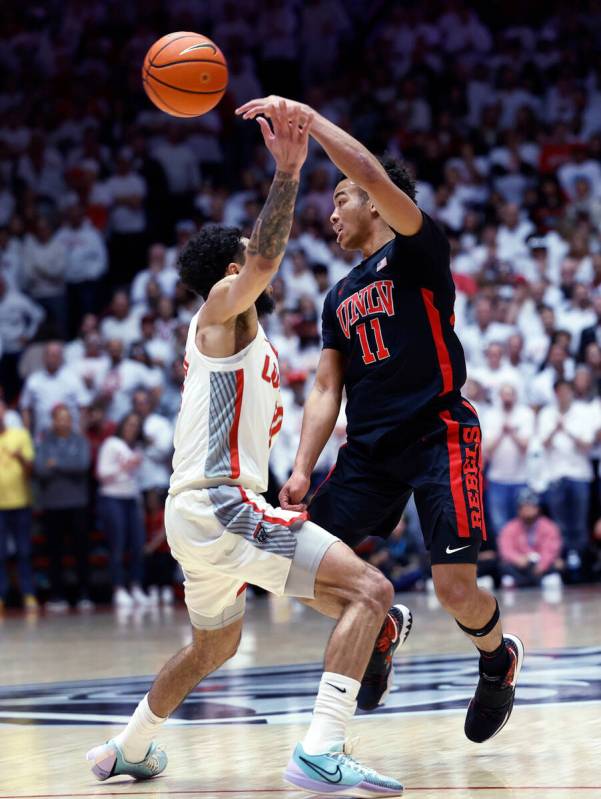 UNLV guard Dedan Thomas Jr. passes the ball as New Mexico guard Jaelen House defends during the ...