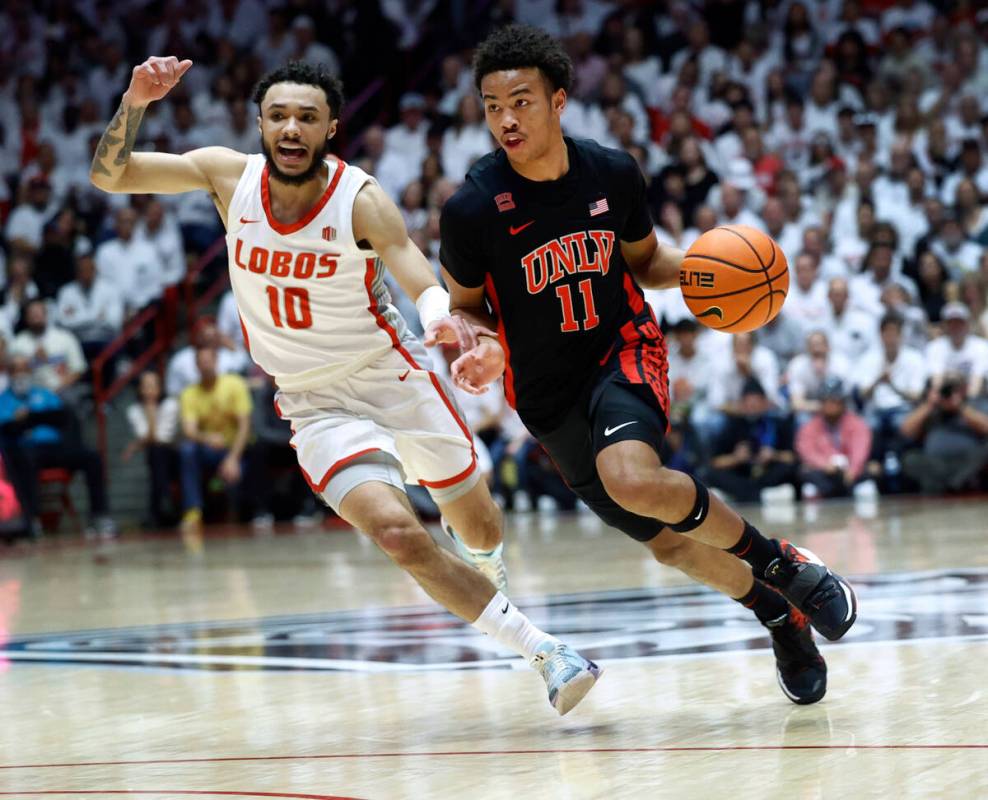 UNLV guard Dedan Thomas Jr dribbles the ball past New Mexico guard Jaelen House during the firs ...