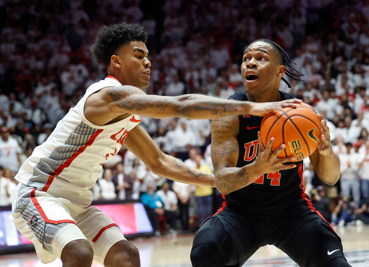 UNLV guard Jackie Johnson III looks for a shot as New Mexico guard Donovan Dent defends during ...