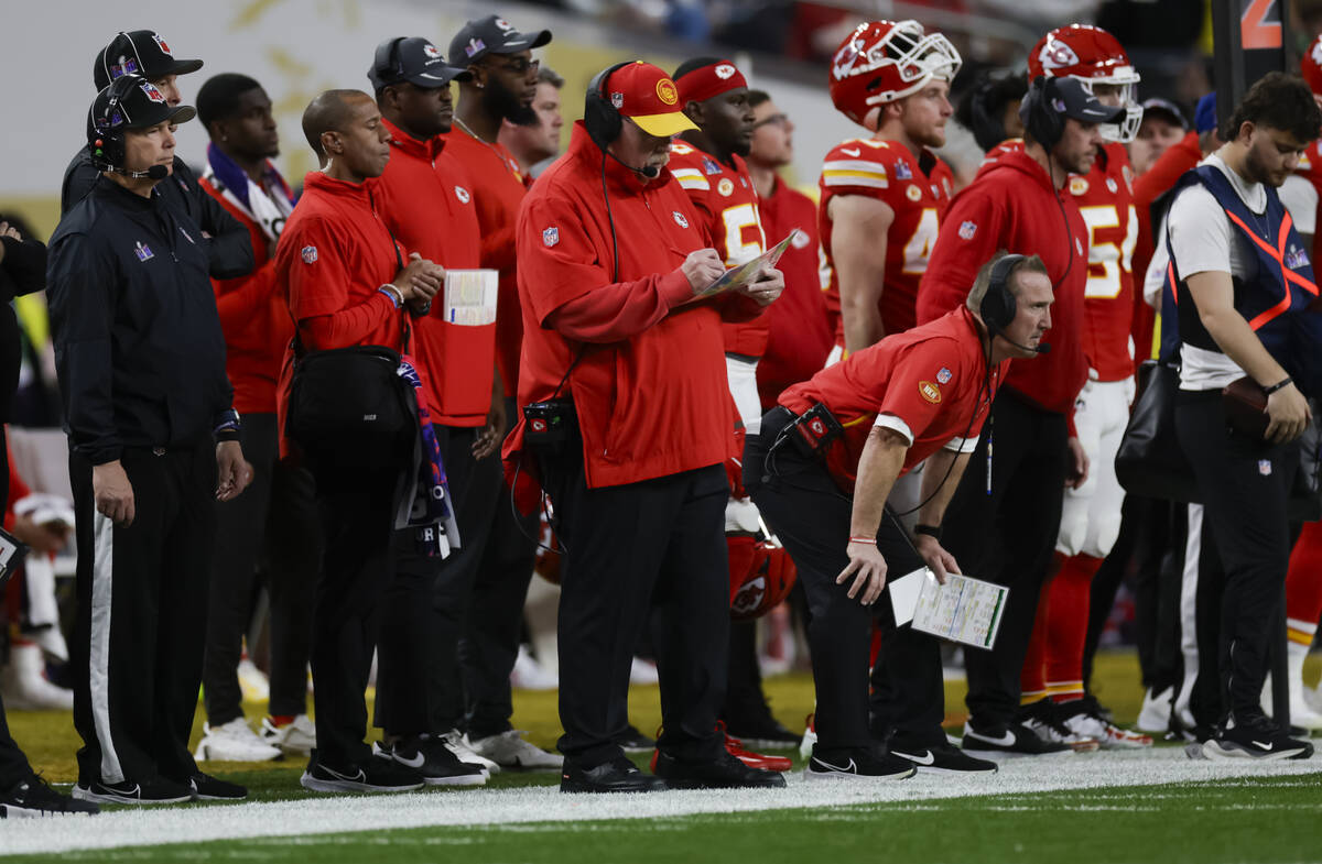 Kansas City Chiefs head coach Andy Reid, center, makes notes during the first half of Super Bow ...