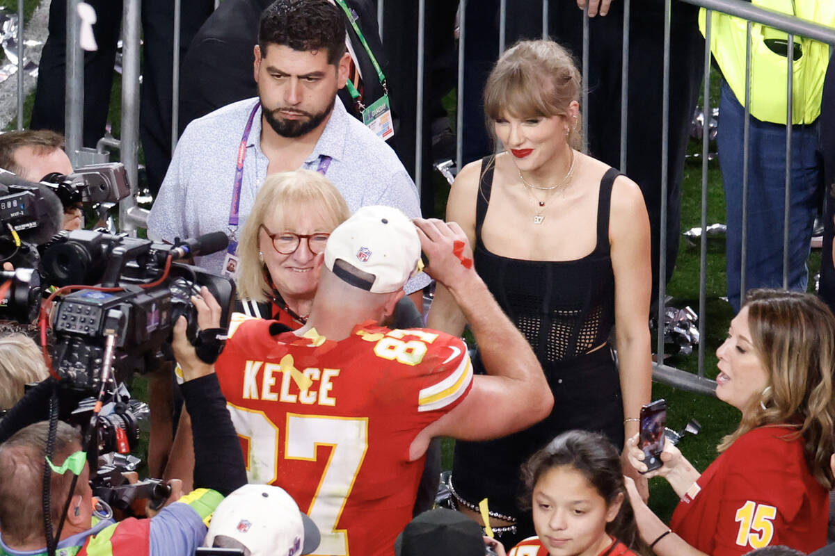 Kansas City Chiefs tight end Travis Kelce (87) greets Taylor Swift as he celebrates their victo ...