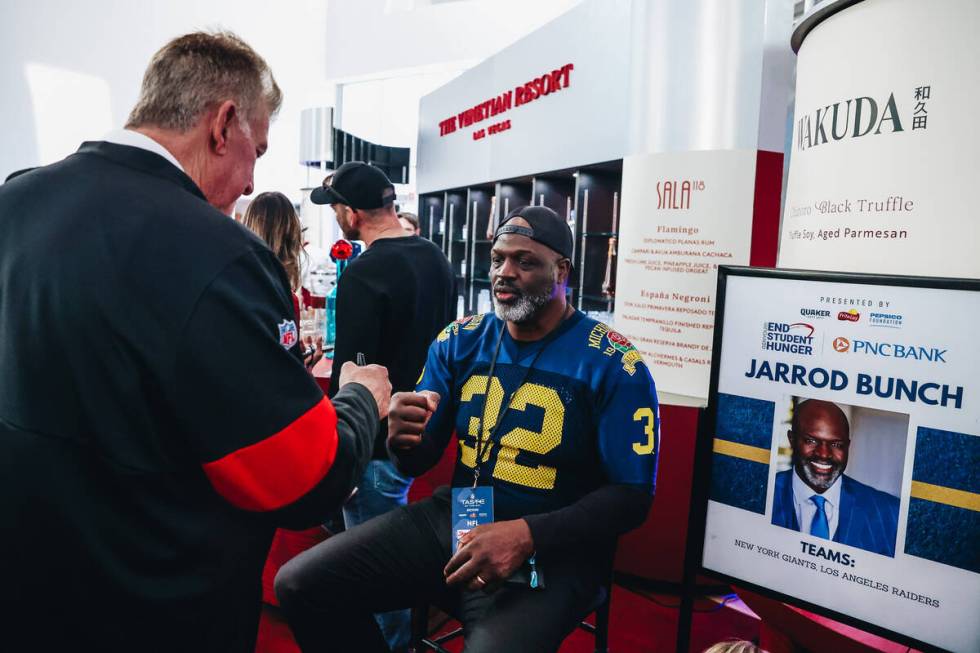 Former NFL player Jarrod Bunch fist bumps a fan at the Taste of NFL event at the Keep Memory Al ...