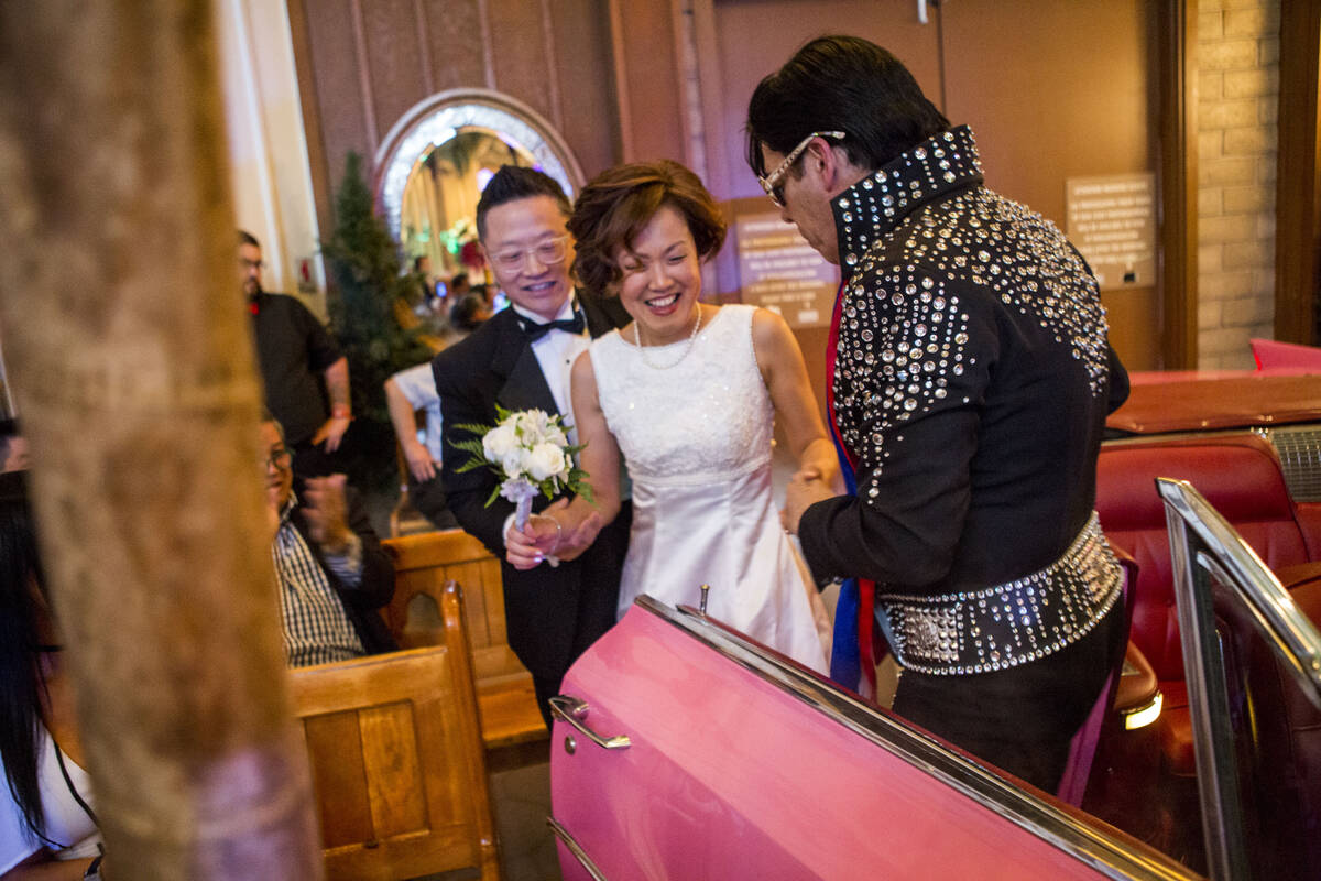 Ron Decar, owner of Viva Las Vegas, helps Julie and Garry Kim out of the pink Cadillac and into ...