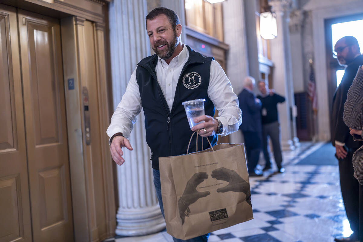 Sen. Markwayne Mullin, R-Okla., arrives with a carryout bag of hamburgers as the Senate prepare ...