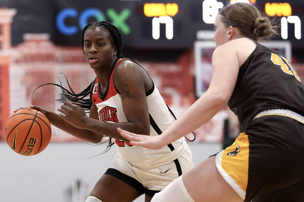 UNLV Lady Rebels center Desi-Rae Young (23) dribbles around Wyoming Cowgirls center Allyson Fer ...