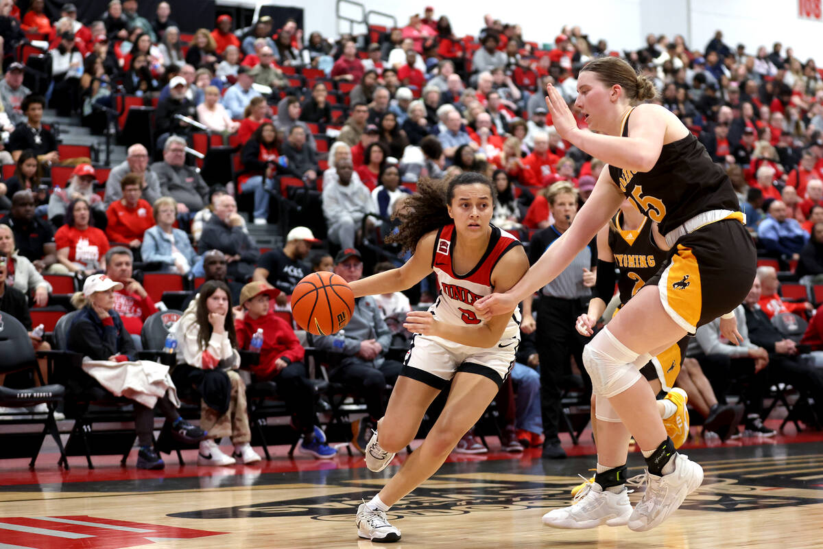 UNLV Lady Rebels guard Kiara Jackson (3) dribbles around Wyoming Cowgirls center Allyson Fertig ...