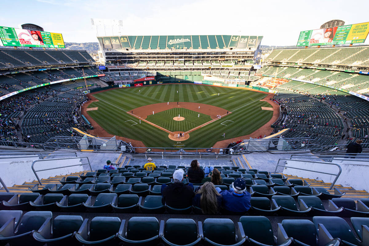 Fans watch a baseball game between the A’s and the Cincinnati Reds at the Oakland Colise ...