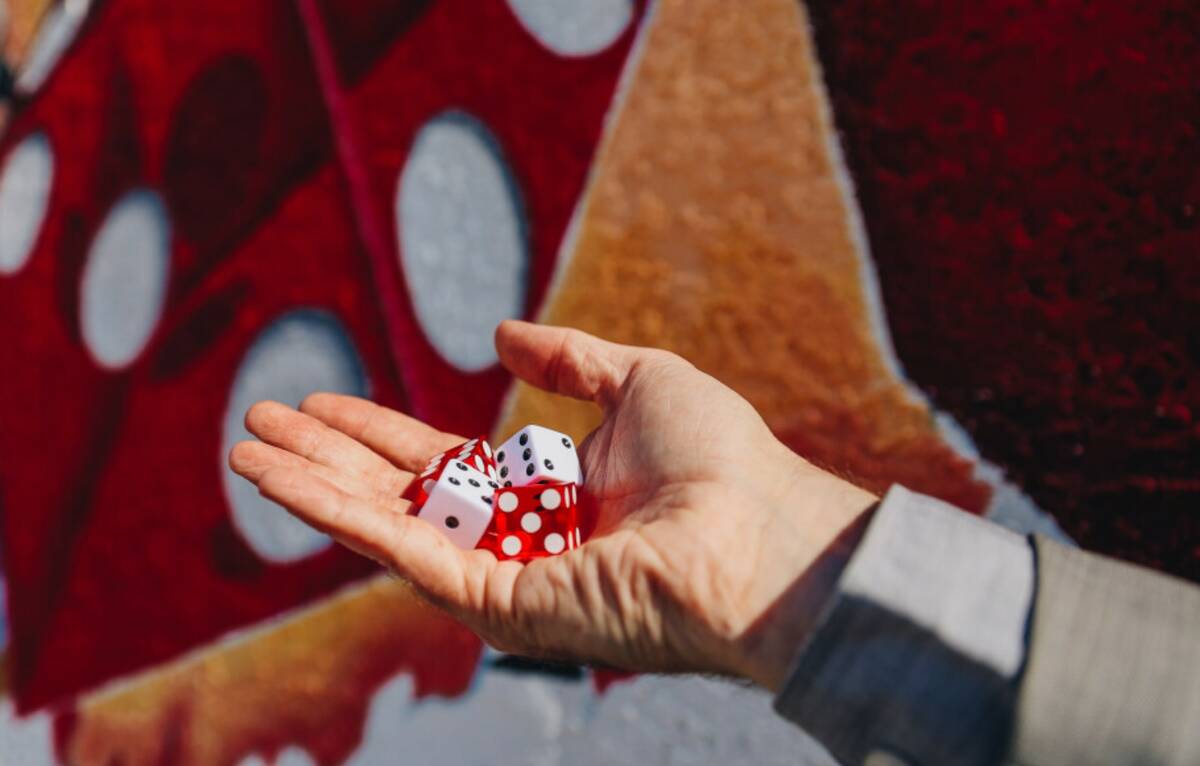 A hand holds both casino and regular dice outside of Gambler’s General Store on Sunday, Feb. ...