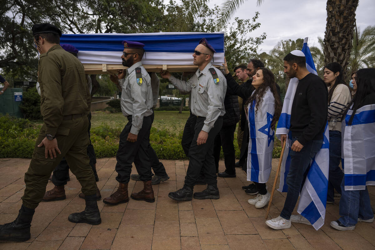 Family members of Israeli reservist Yair Cohen follow his flag-draped casket during his funeral ...