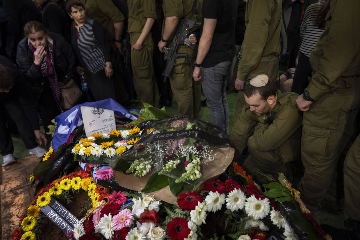 Family and friends of Israeli reservist Yair Cohen gather around his grave during his funeral a ...