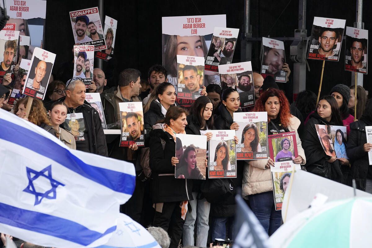 Families of hostages and former hostages hold images on a podium at a protest near the Internat ...