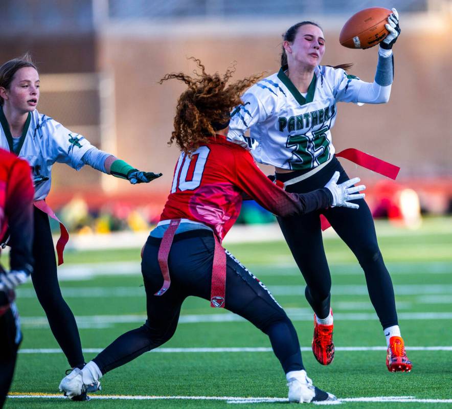 Palo Verde running back Tia Brown (35) works to evade a flag pull by Desert Oasis defender Broo ...