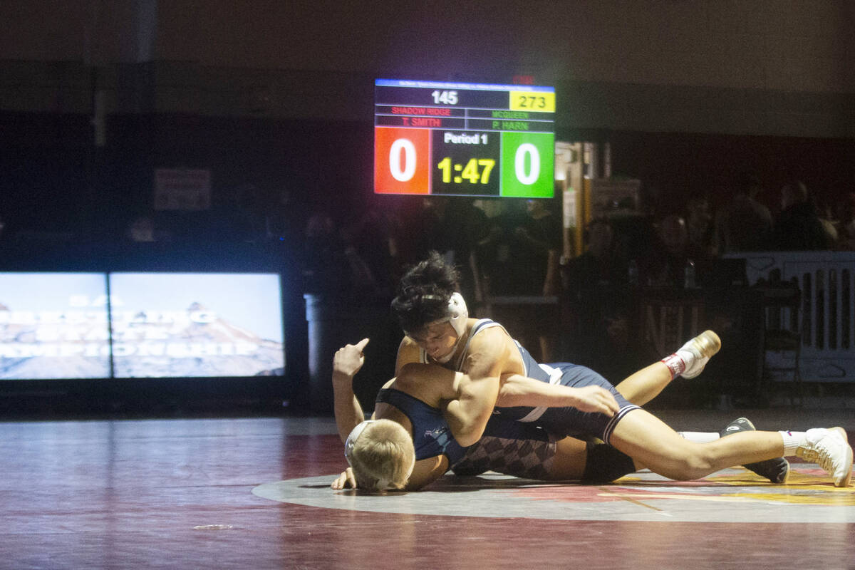 Shadow Ridge High School’s Trent Smith, top, wrestles McQueen High School’s Prest ...