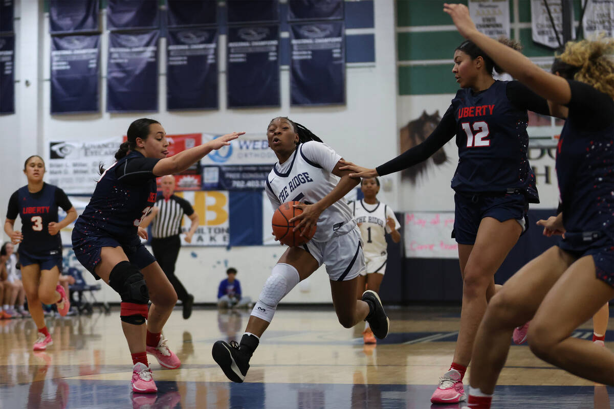 Shadow Ridge guard Zh'mya Martin (5) drives toward the hoop between Liberty's Leiliani Harworth ...