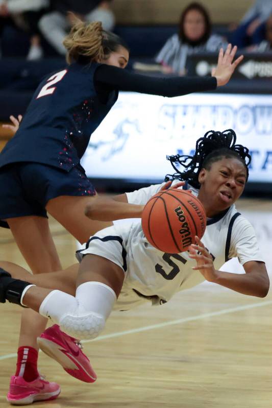 Shadow Ridge guard Zh'mya Martin (5) flies to the court after Liberty's Lillian Hastings (2) fo ...