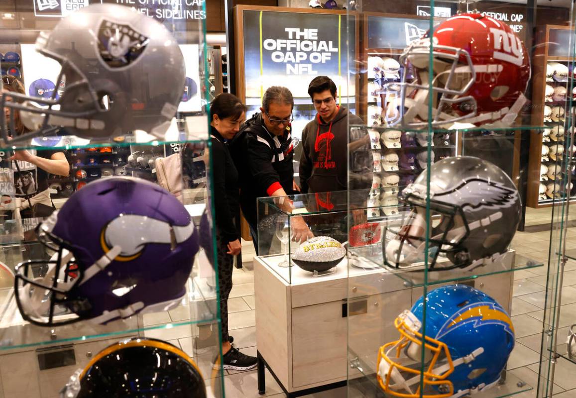 Shoppers check out Super Bowl LVIII merchandise at the NFL Las Vegas store at the Forum Shops, ...