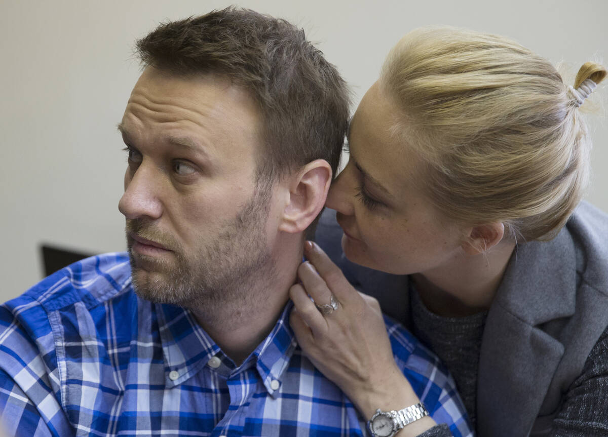 FILE - Russian opposition activist Alexei Navalny and his wife Yulia talk in a courtroom before ...