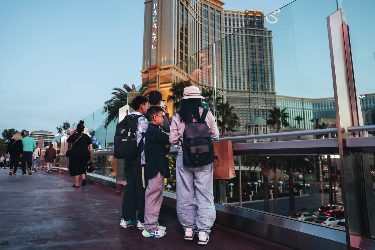 A family stops on a pedestrian walkway to take photographs of the Strip on Friday, Feb. 16, 202 ...