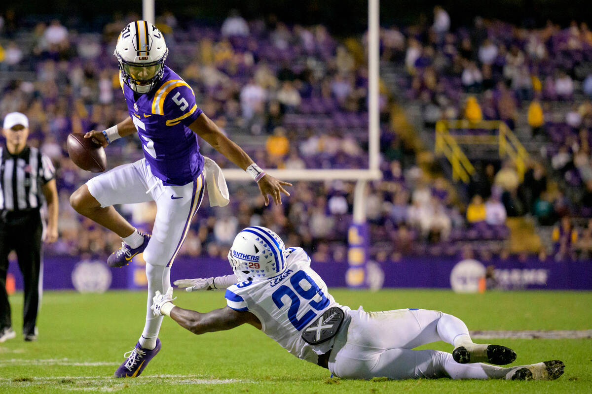 DFILE - LSU quarterback Jayden Daniels (5) breaks away from Georgia State safety TyGee Leach (2 ...