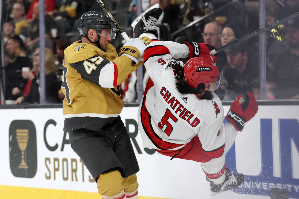 Golden Knights center Ivan Barbashev (49) checks Hurricanes defenseman Jalen Chatfield (5) duri ...