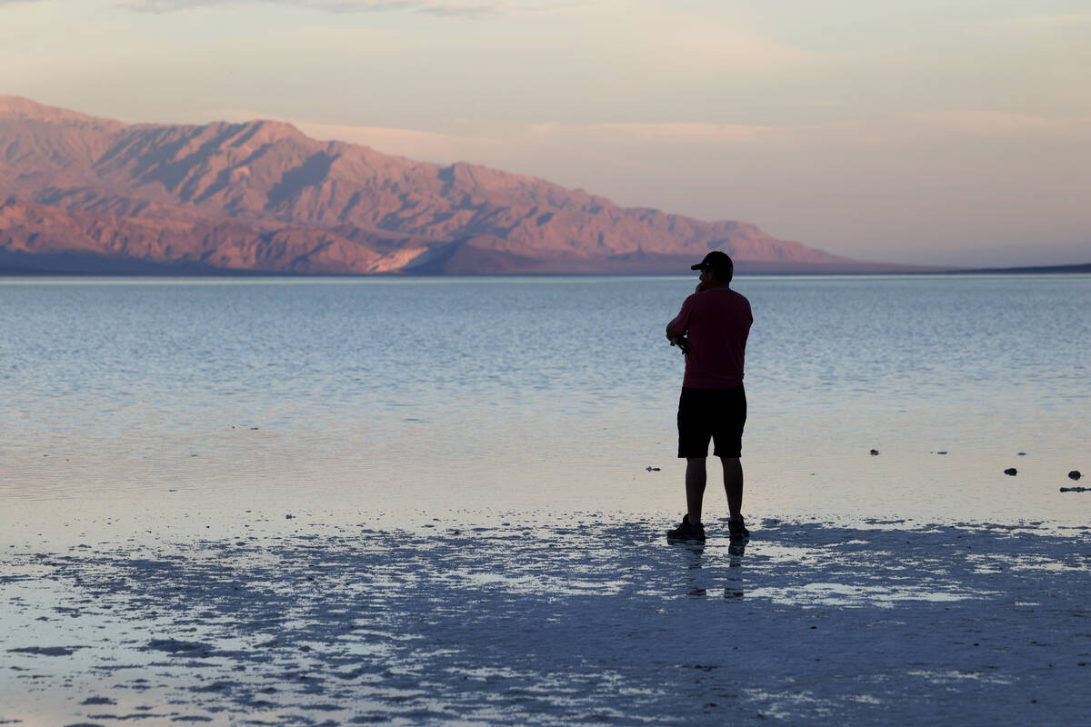 A visitor checks out a rare lake in Badwater Basin in Death Valley National Park in California ...