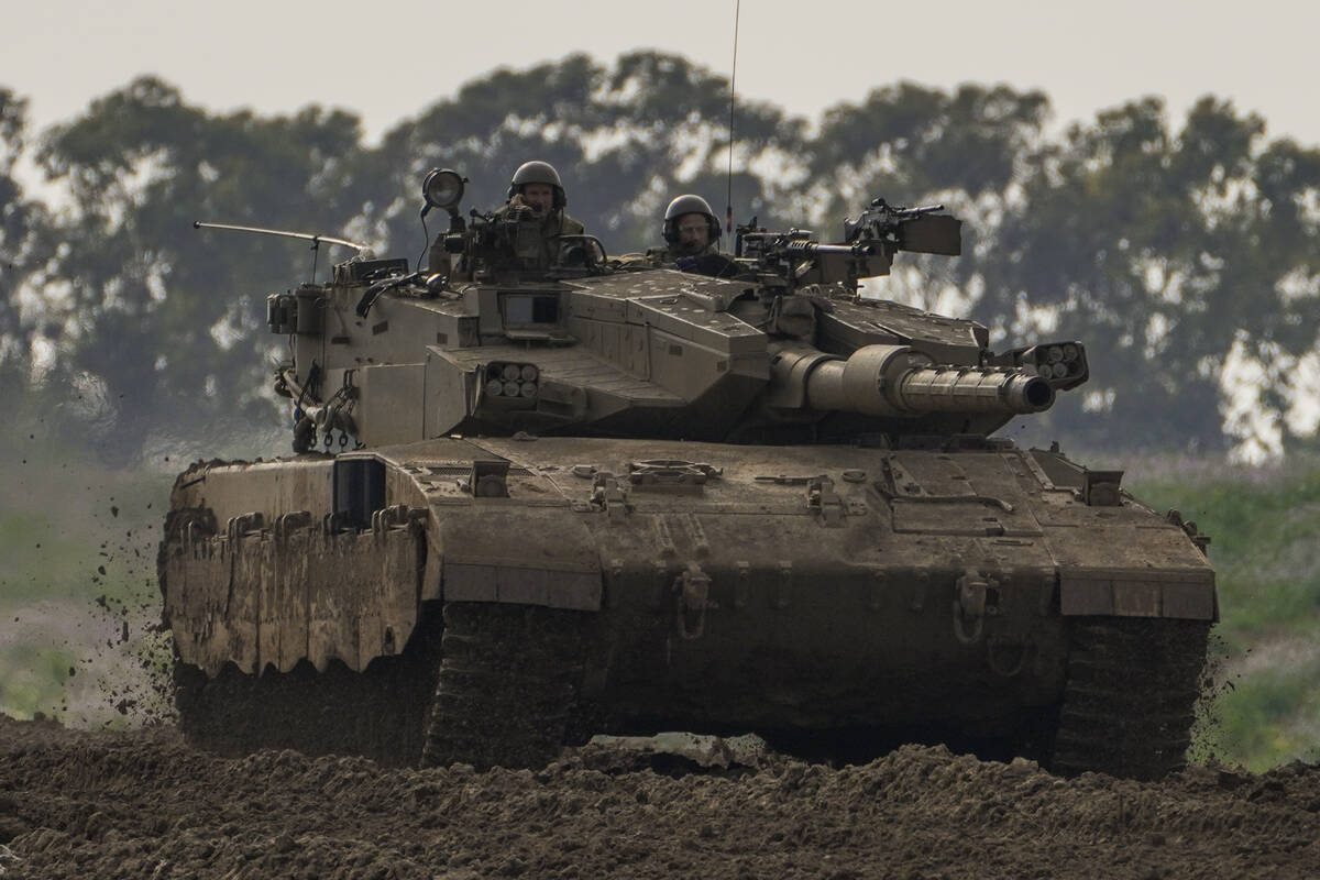 Israeli soldiers drive a tanks near the Gaza Strip border, in southern Israel, Monday, Feb. 19, ...