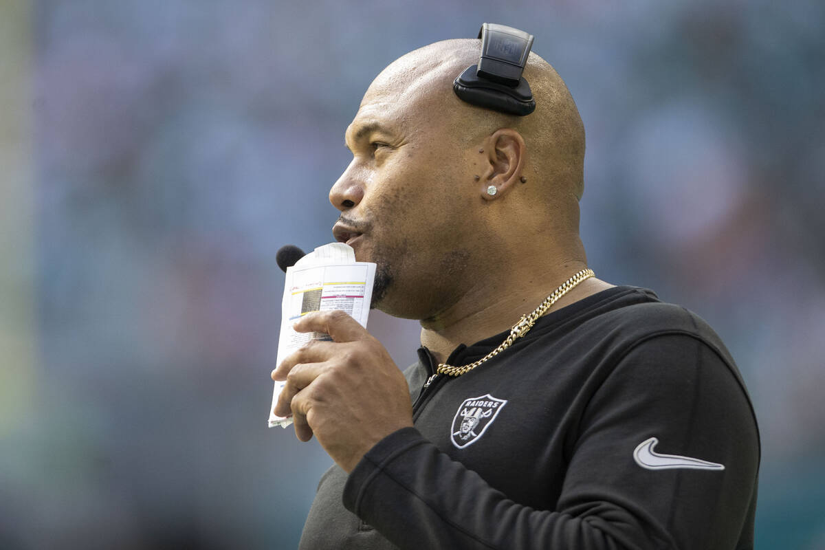 Raiders interim head coach Antonio Pierce speaks into his headset during the second half of an ...