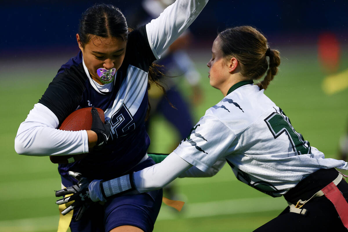 Shadow Ridge's Jaylani Palmer (12) runs the ball while Palo Verde's Samantha Manzo (26) snags h ...