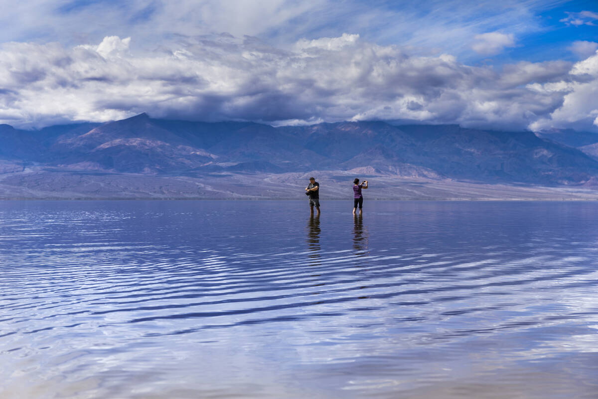 Visitors wander out and take photos on the temporary Lake Manly at Badwater Basin in Death Vall ...