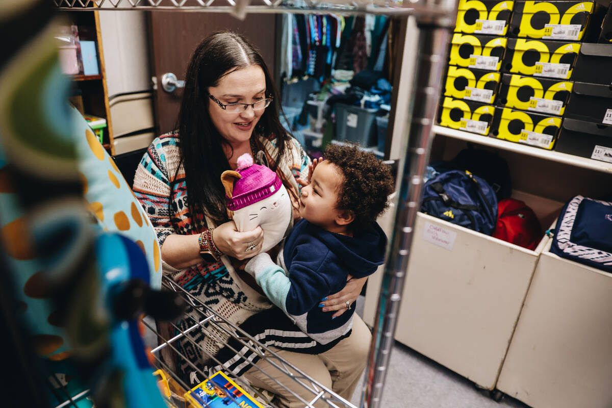 Katie Krikorian, left, holds out a squishmallow toy for her adopted son, Isaac Krikorian, 1, at ...