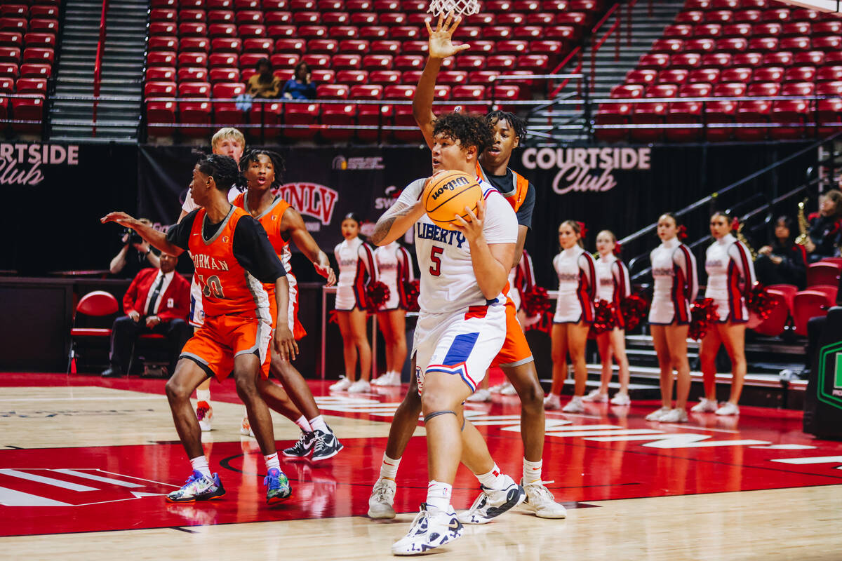 Liberty small forward Andre Porter (5) passes the ball to a teammate during a Class 5A boys bas ...