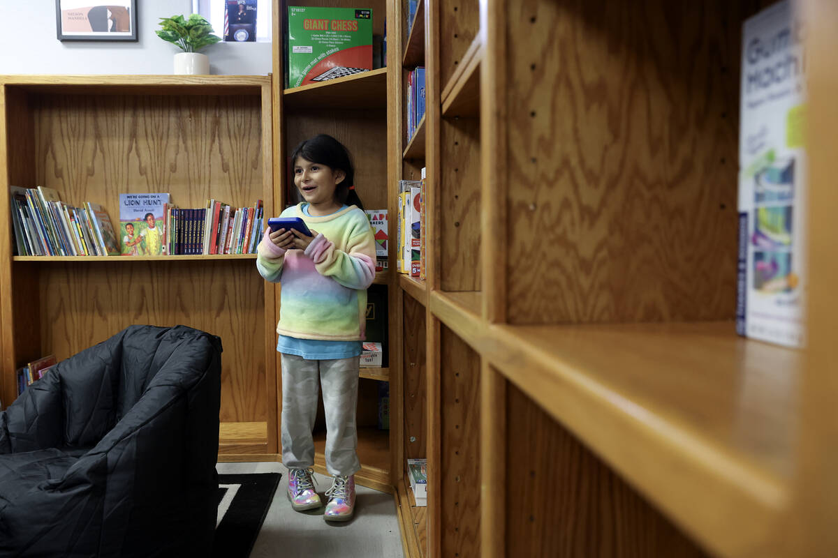 Maya Dzul, 6, makes a selection in the library during an opening event at the Donna Street Comm ...