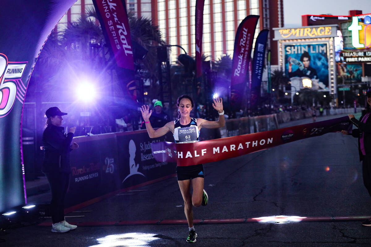 Sarah Pagano, of San Diego, runs through the finish line to win the women’s category for ...