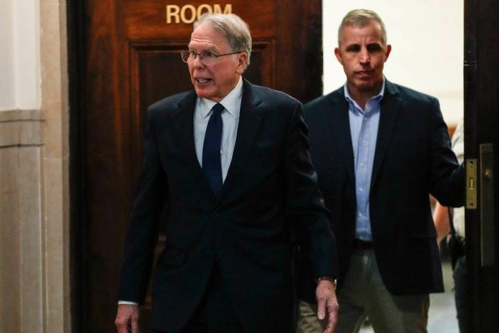 Wayne LaPierre, left, CEO of the National Rifle Association, leaves the courtroom as a jury con ...