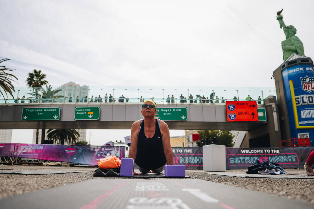 A person does yoga on the Strip while it is shut down for the Rock ’n’ Roll Runni ...