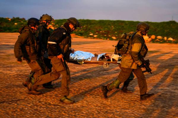Israeli soldiers run as they carry a stretcher towards a military helicopter during an exercise ...