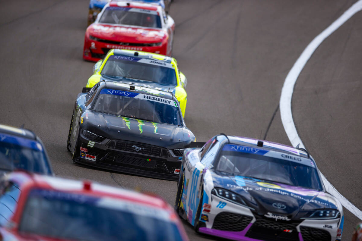 Driver Riley Herbst, 98, battles to move up during the LiUNA NASCAR Xfinity Series race at the ...