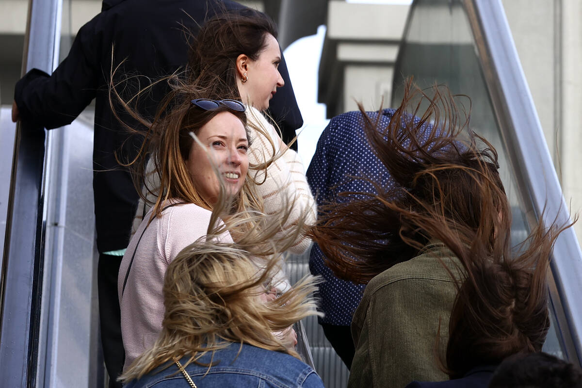 Visitors to the Las Vegas Strip brave gusts as a high wind warning is in effect on Saturday, Ma ...