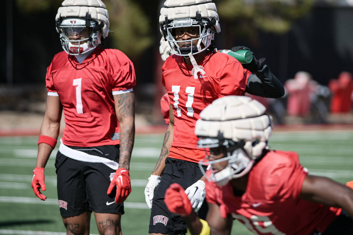 UNLV wide receivers Casey Cain, left, and Ricky White III watch a drill during take the first d ...