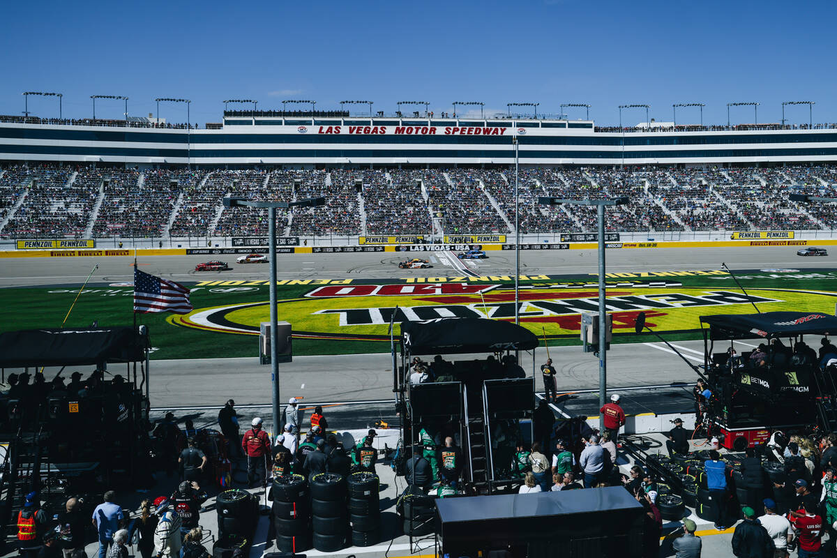 Pit crews watch as cars race by at the Pennzoil 400 NASCAR Cup Series race at the Las Vegas Mot ...