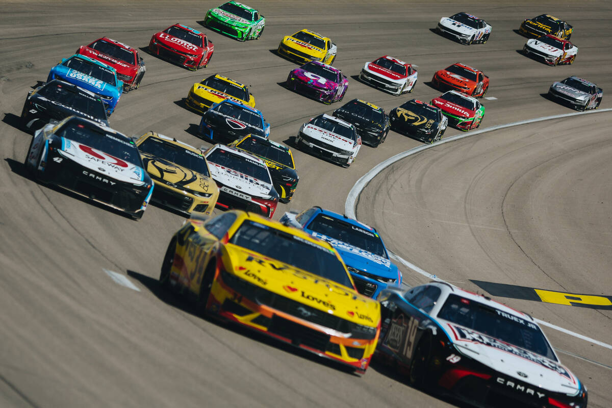 Race cars drive by at the Pennzoil 400 NASCAR Cup Series race at the Las Vegas Motor Speedway o ...
