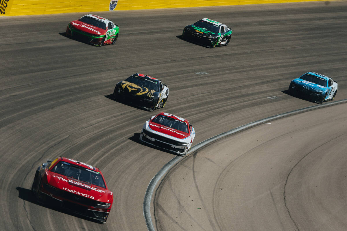 Race cars drive by at the Pennzoil 400 NASCAR Cup Series race at the Las Vegas Motor Speedway o ...