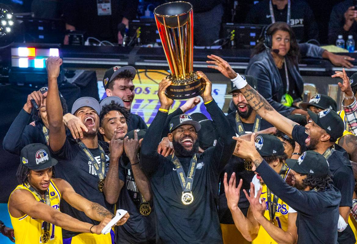 Los Angeles Lakers forward LeBron James (23) holds up the winning trophy about teammates after ...