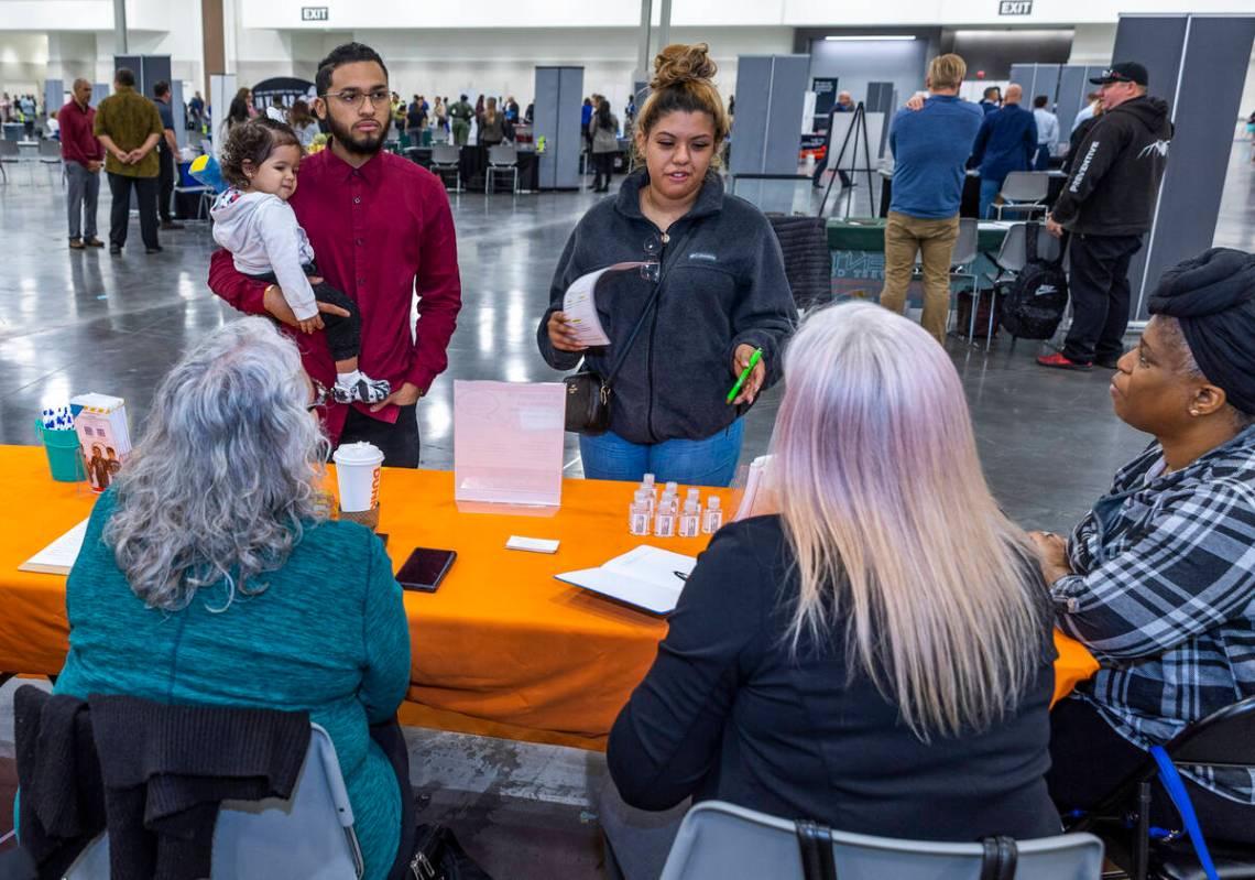 Job seekers Nadia Mihailovic, center, with Ricardo Rivera and their child Iyannah Cuza, 1, spea ...