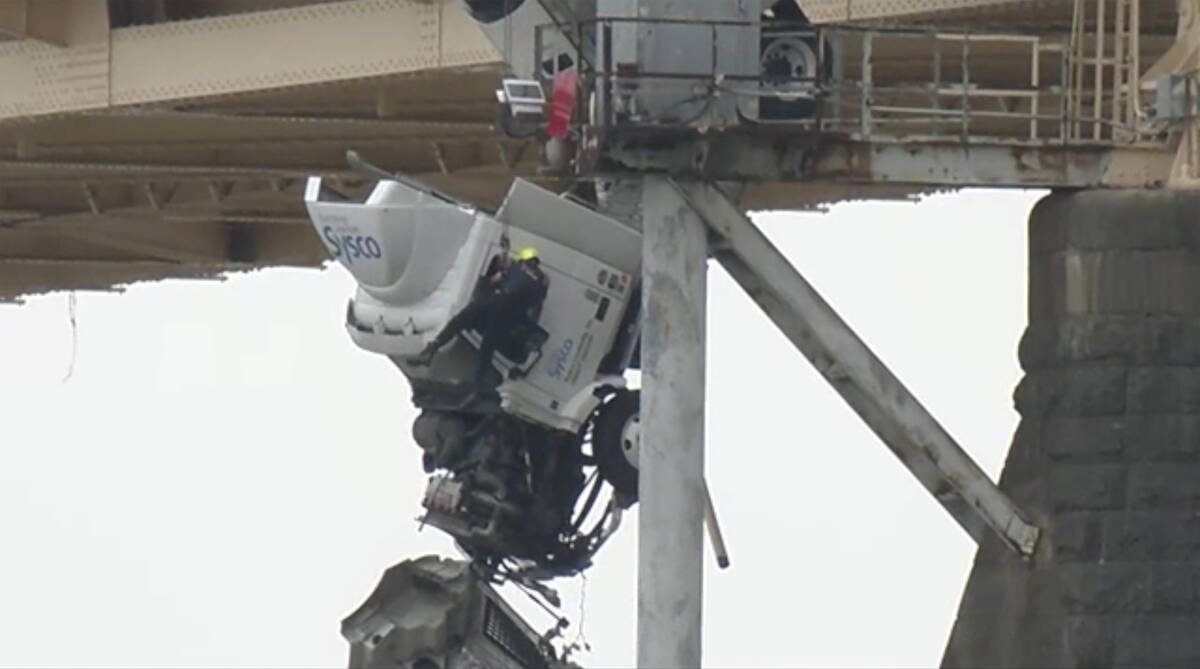 Louisville emergency crews rescue the driver of semitruck that is dangling off the Clark Memori ...